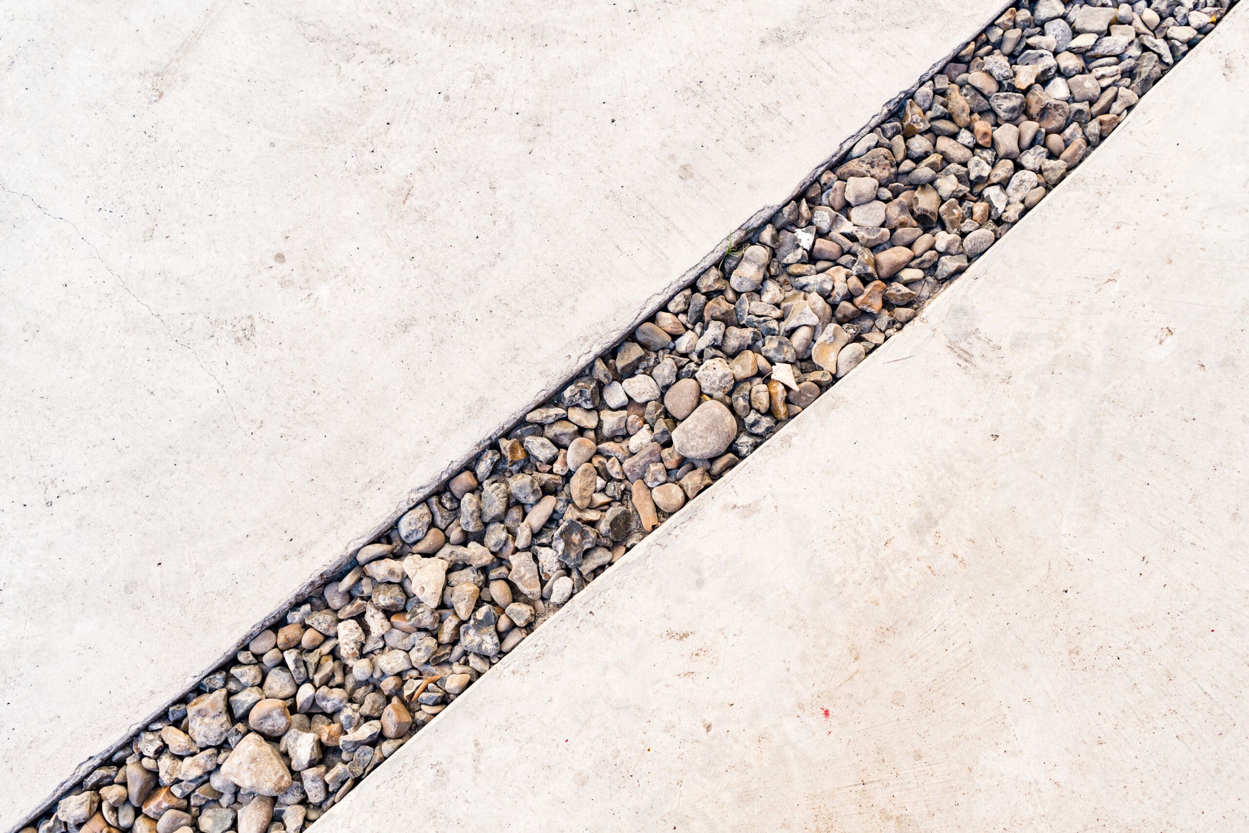 cement background crossed by diagonal line pebbles stone scaled
